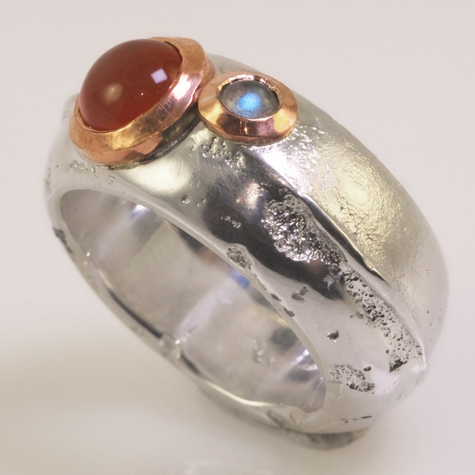 Close-up of dual cabochons in copper bezel on sand-cast sterling silver ring, handmade in Copenhagen