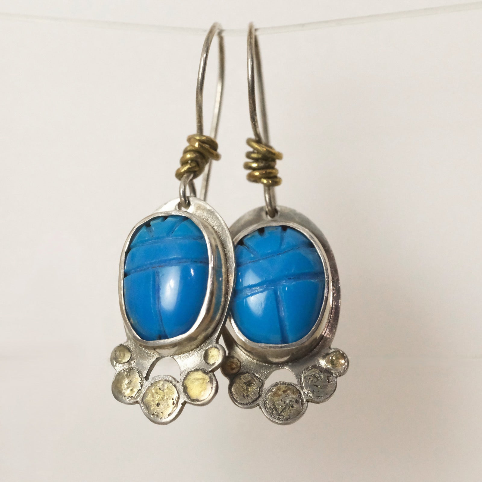 Artisan silver and brass earrings with carved turquoise