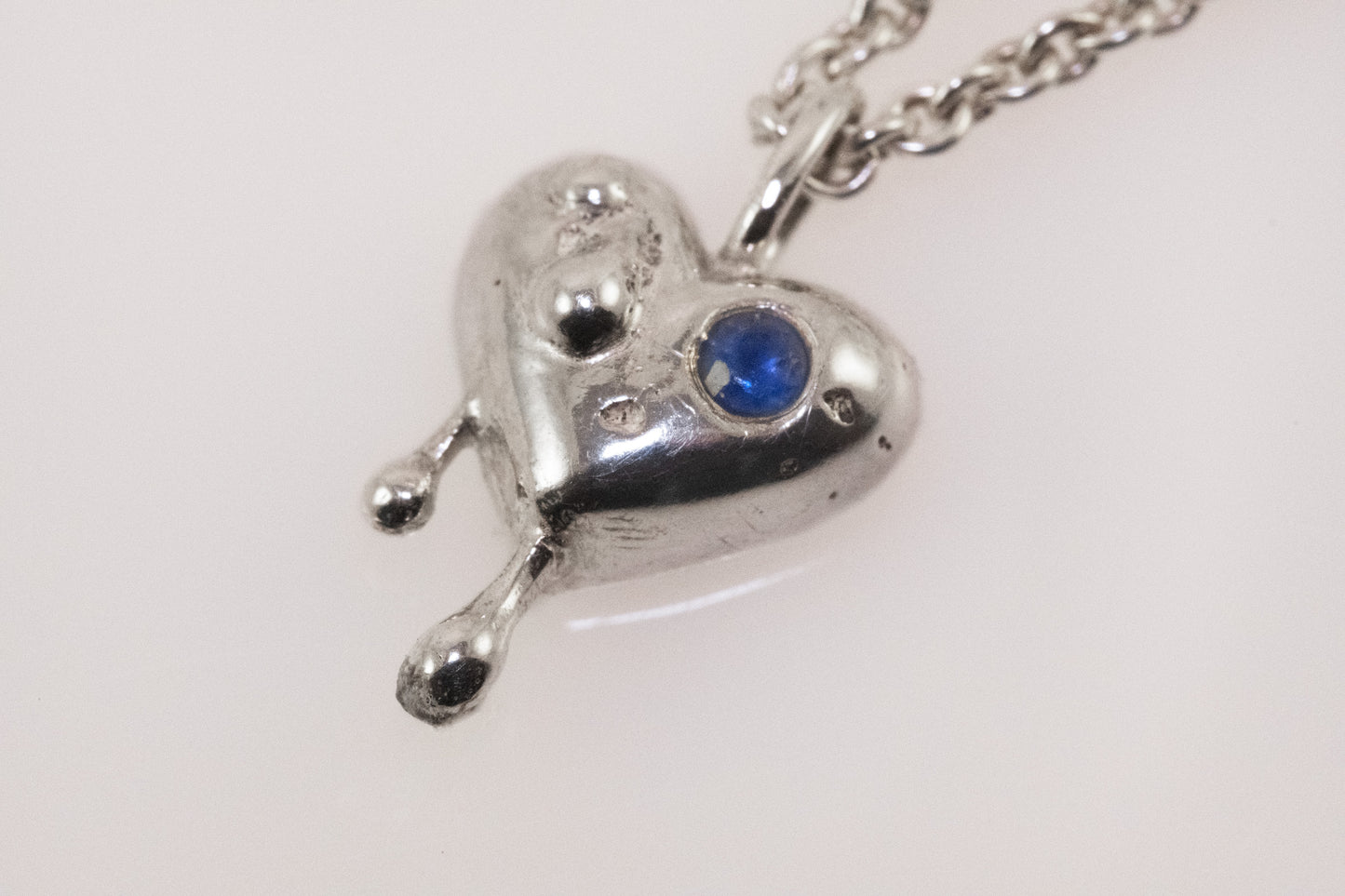 Close-up of blue zirconia detail on silver heart pendant by VerdeRame Jewels