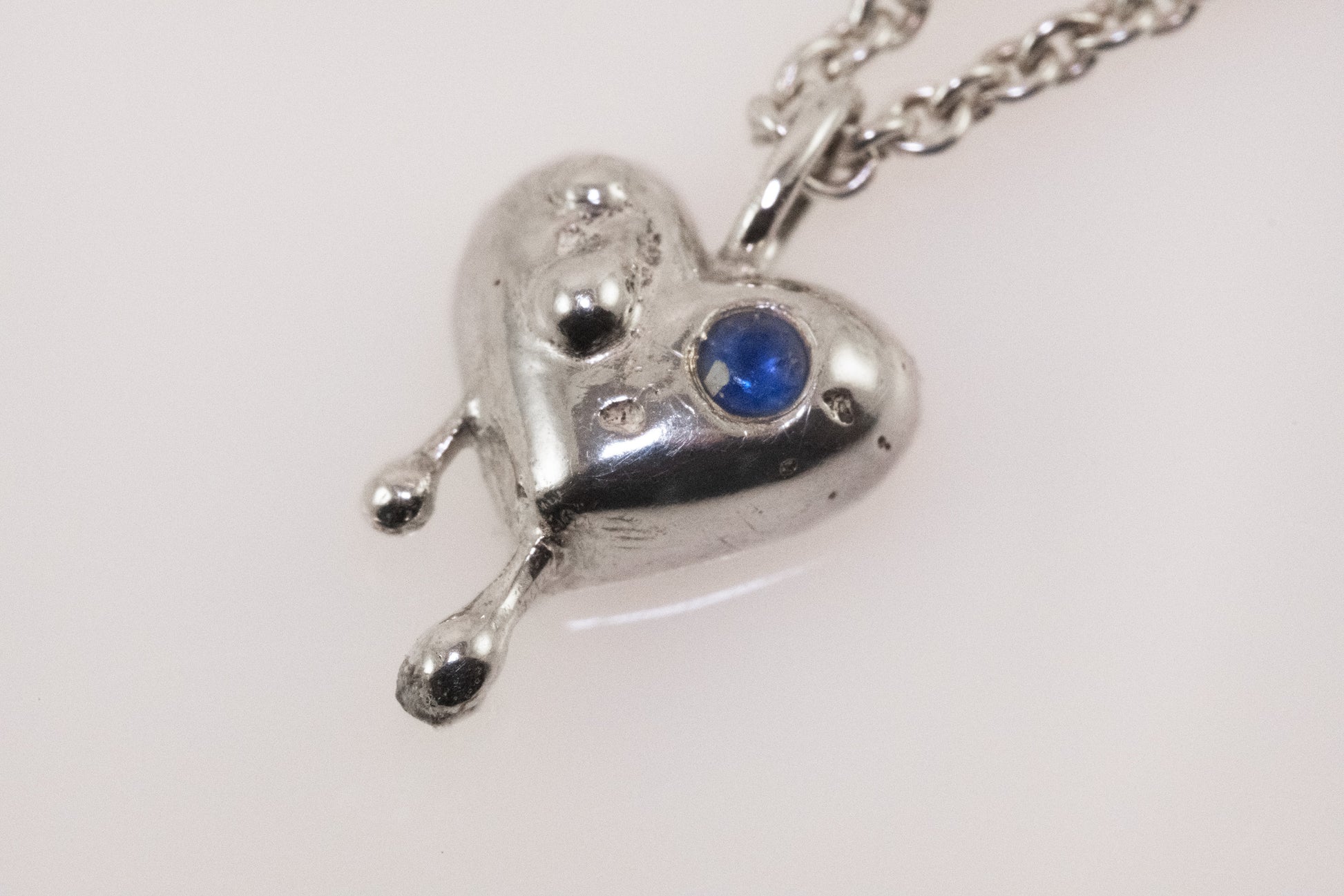 Close-up of blue zirconia detail on silver heart pendant by VerdeRame Jewels