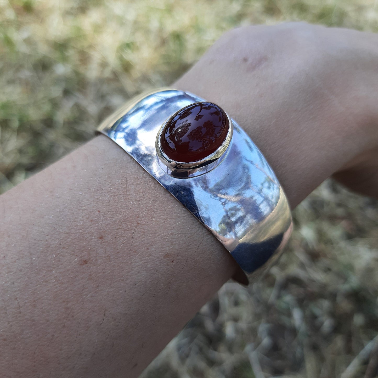 Polished silver bangle with hammered finish and carnelian