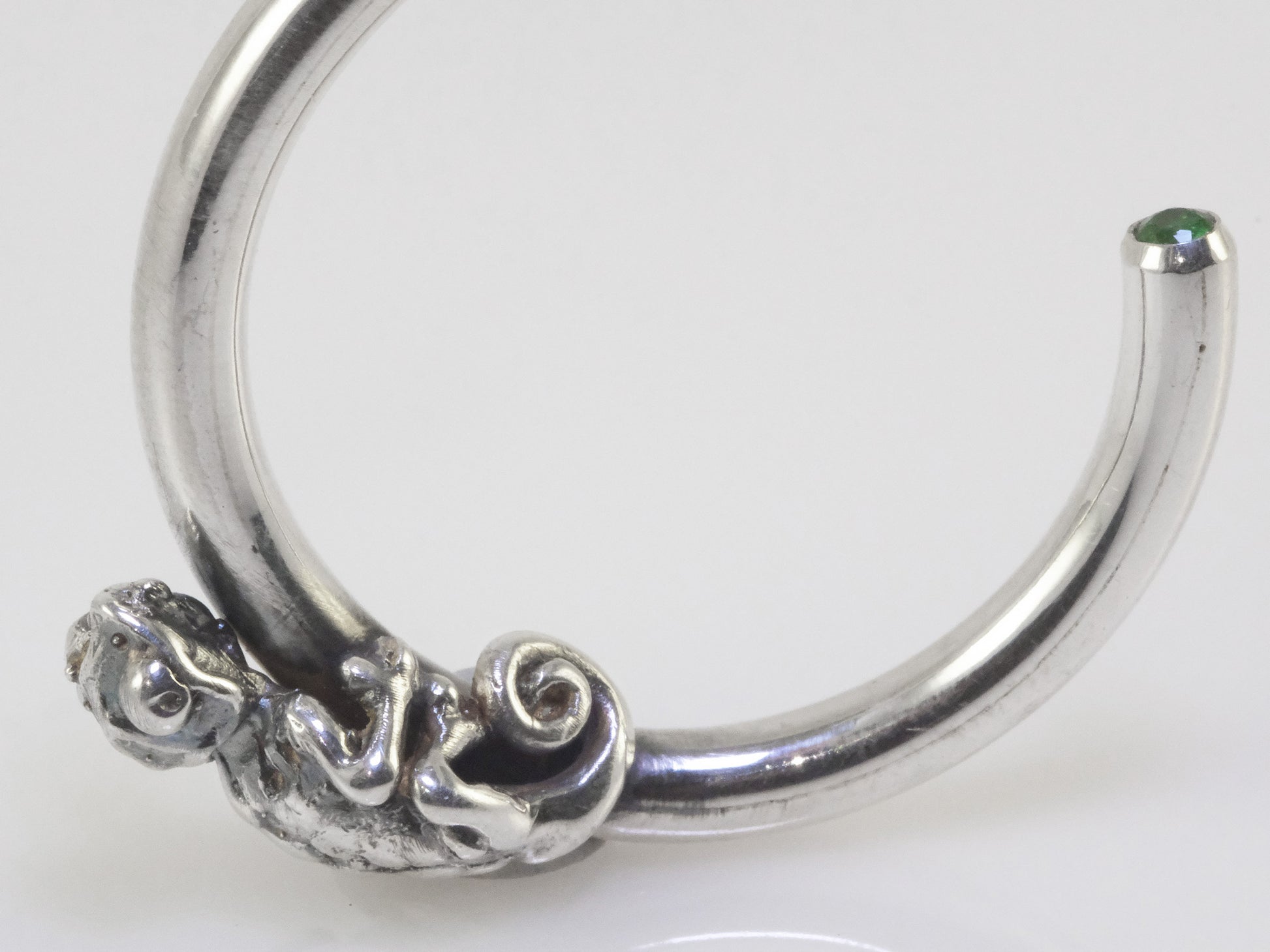 Detail of artisan animal hoop earrings sterling silver chameleon design