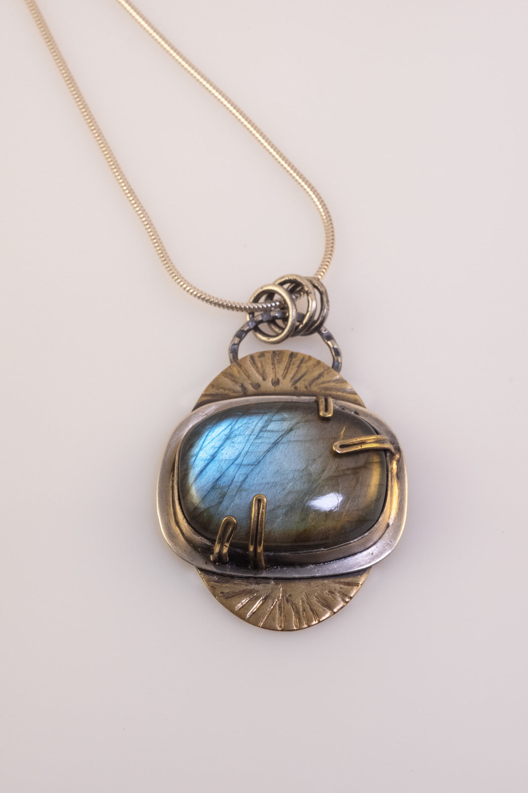 Handmade labradorite storm pendant in sterling silver and brass
