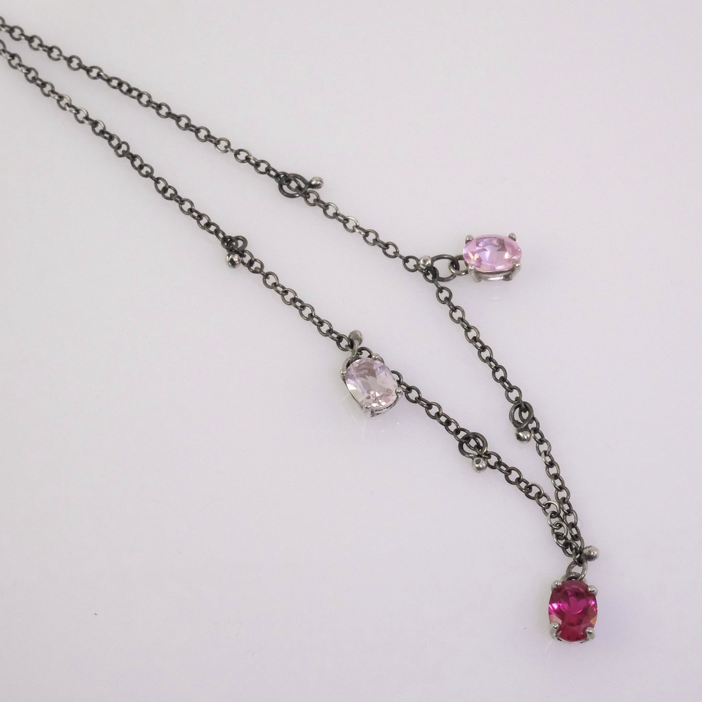 Quirky oxidised silver necklace with oval crystals in white, fuchsia, and baby pink, handmade by VerdeRame Jewels.
