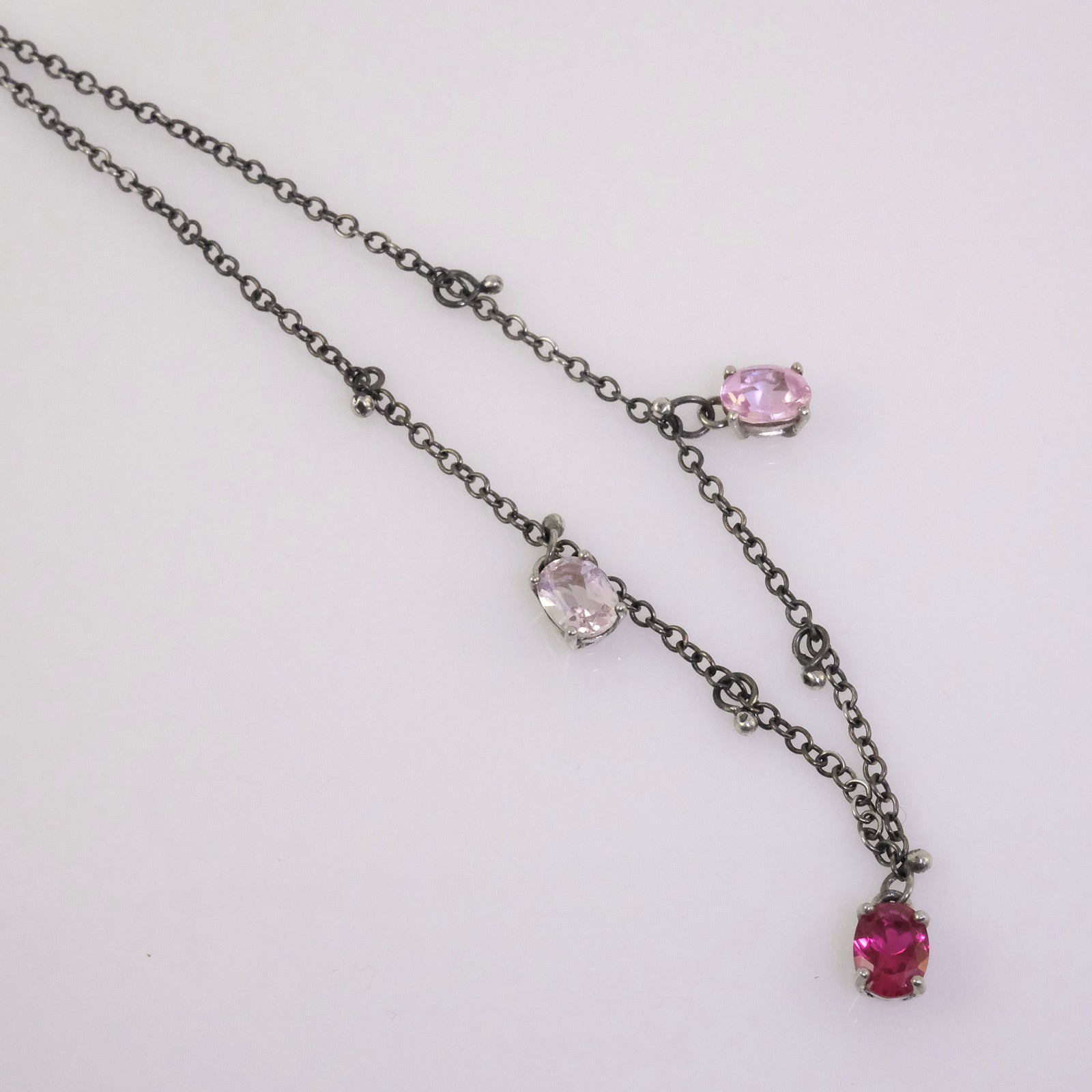 Quirky oxidised silver necklace with oval crystals in white, fuchsia, and baby pink, handmade by VerdeRame Jewels.