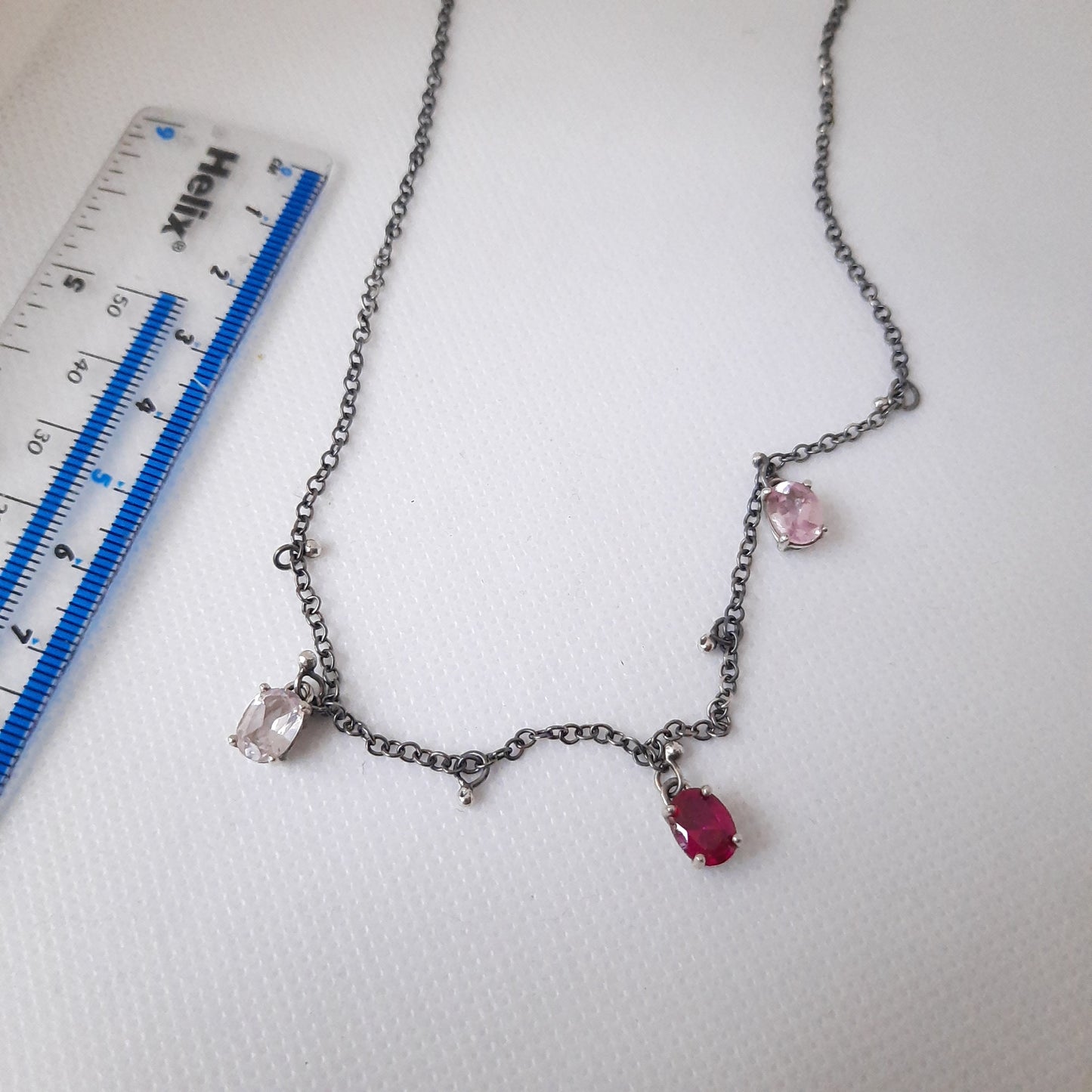 Handmade oxidised silver necklace featuring oval crystals and tiny silver ball charms, showing the craftsmanship.