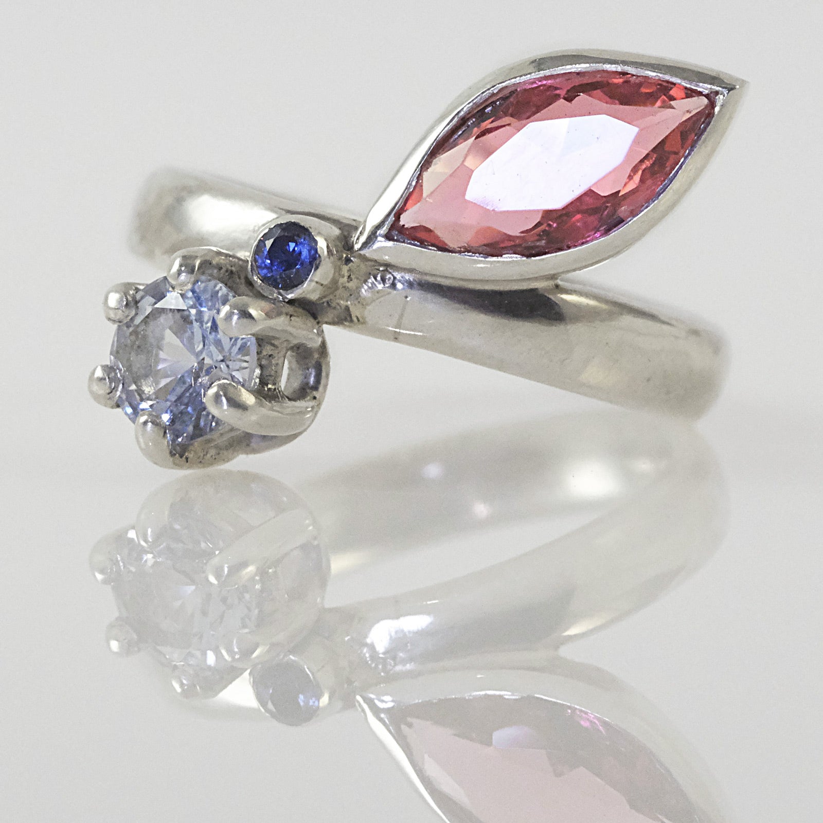 Three-stone silver ring with blue, pink, and aqua crystals