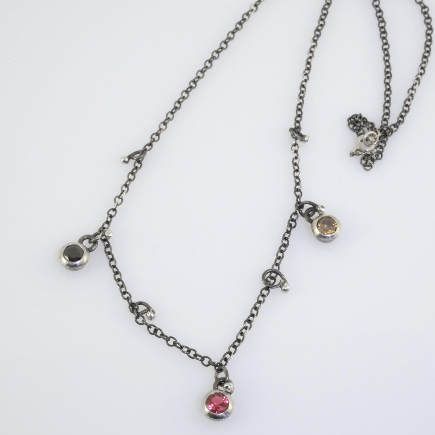 Handcrafted silver necklace with black, fuchsia, and yellow crystal beads