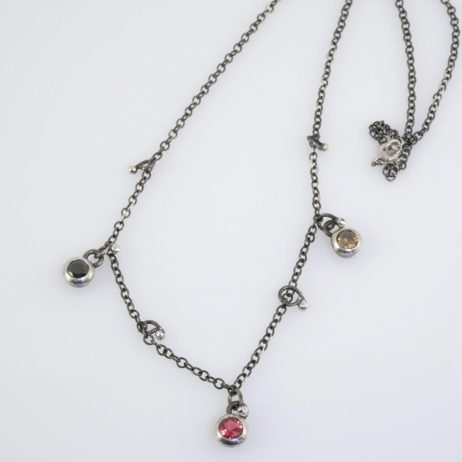 Handcrafted silver necklace with black, fuchsia, and yellow crystal beads