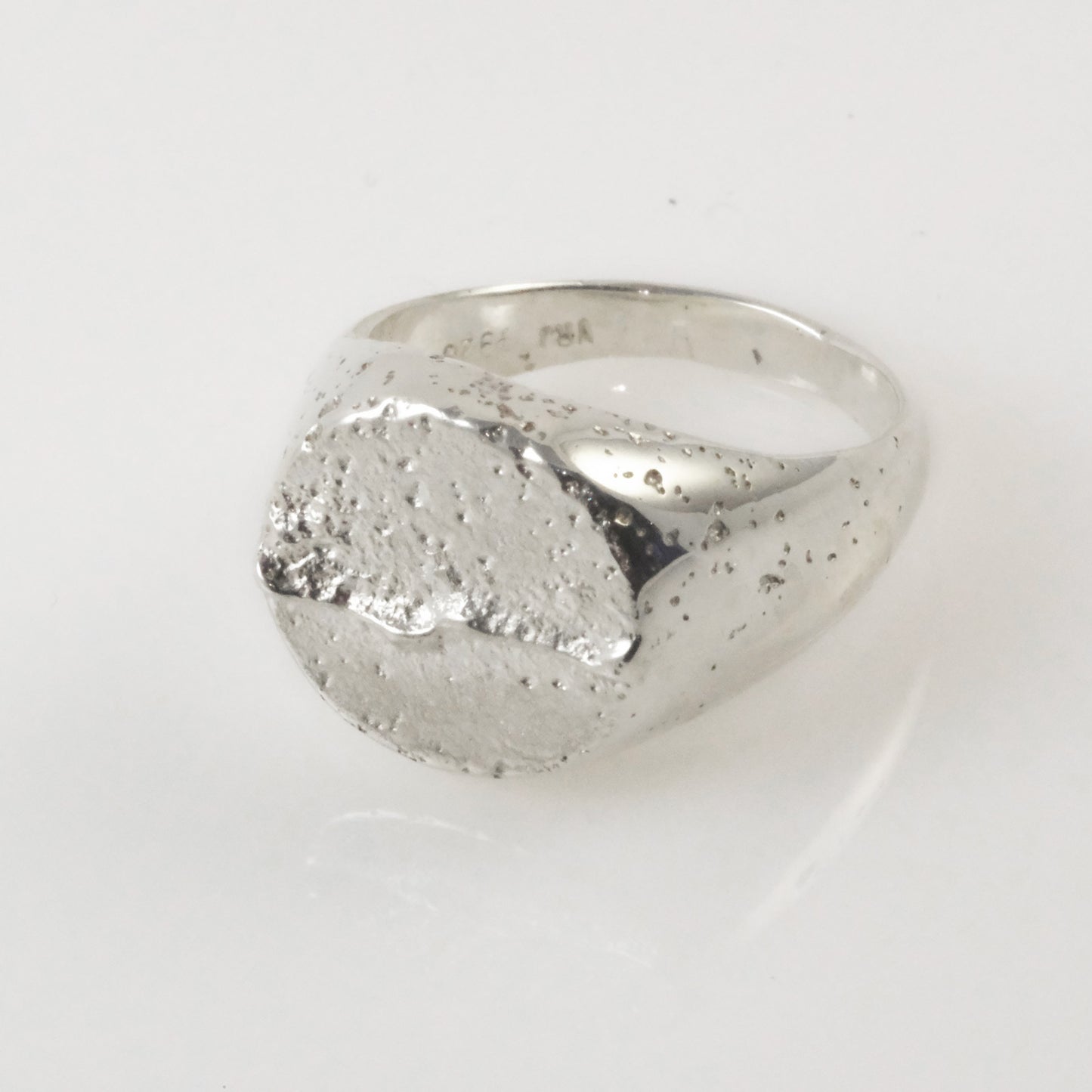 Close-up of textured sand-cast sterling silver signet ring, handmade in Copenhagen