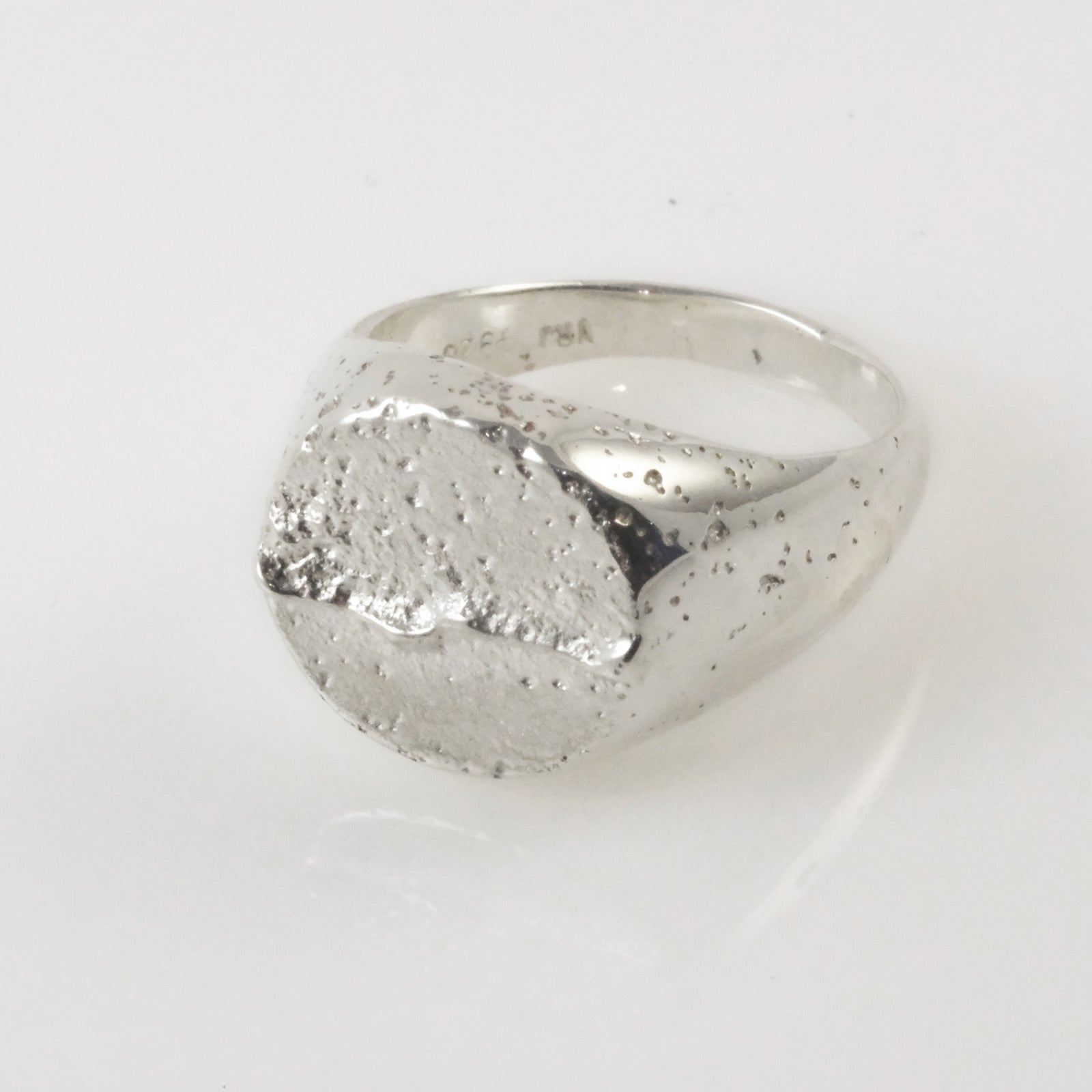 Close-up of textured sand-cast sterling silver signet ring, handmade in Copenhagen