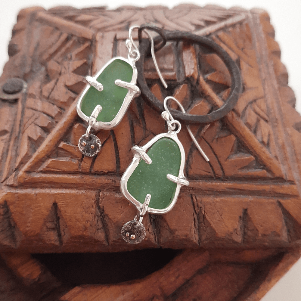 Detail of sea glass earrings with handmade silver prong setting