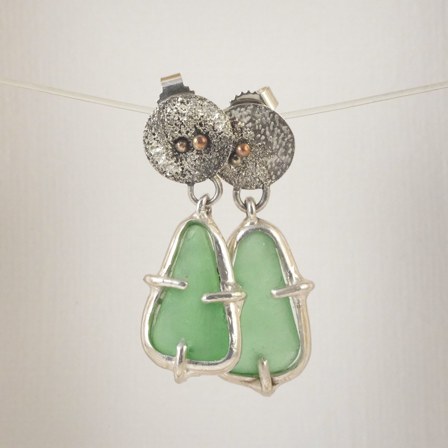 Artisan sea glass earrings with textured silver and copper detail