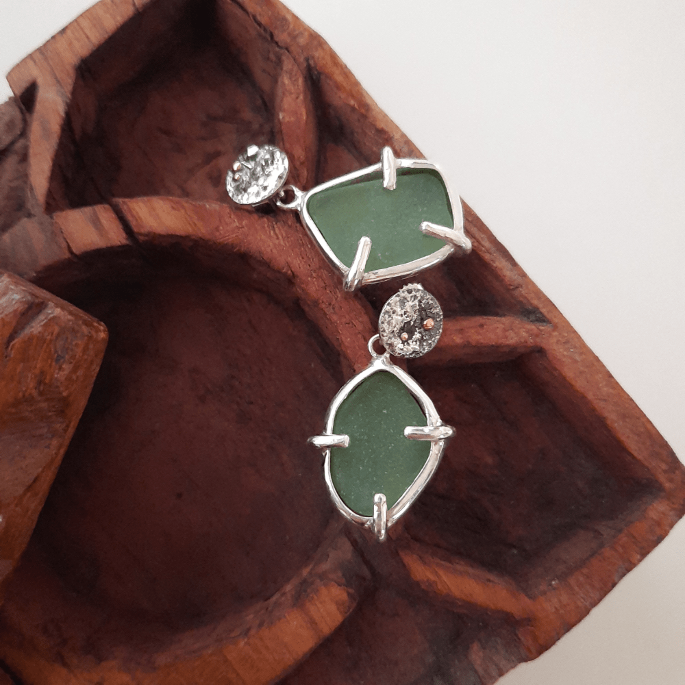 Detail of handmade sea glass earrings with sterling silver prong setting