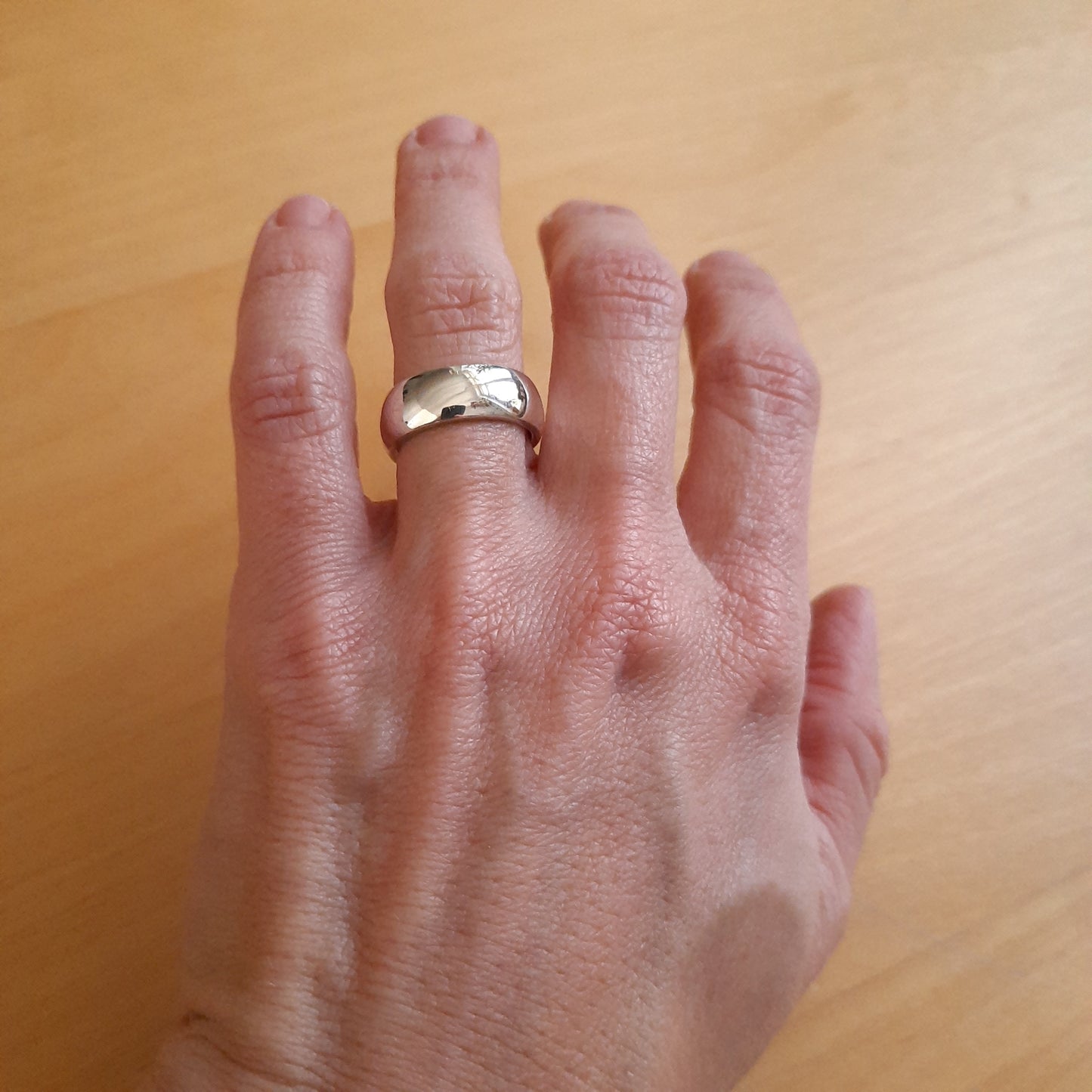 Artisan handmade silver ring with smooth curved design.