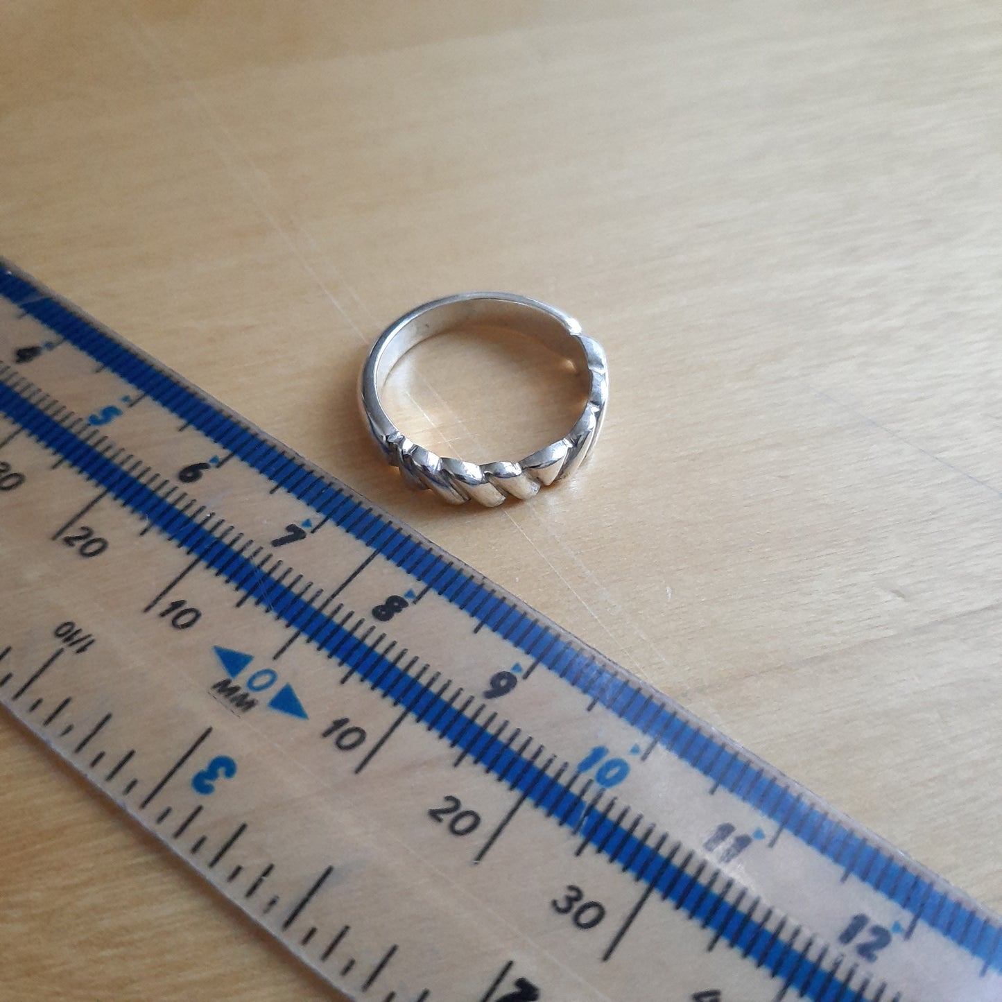 Close-up of retro-style silver scallop band showing handcrafted texture and curves.