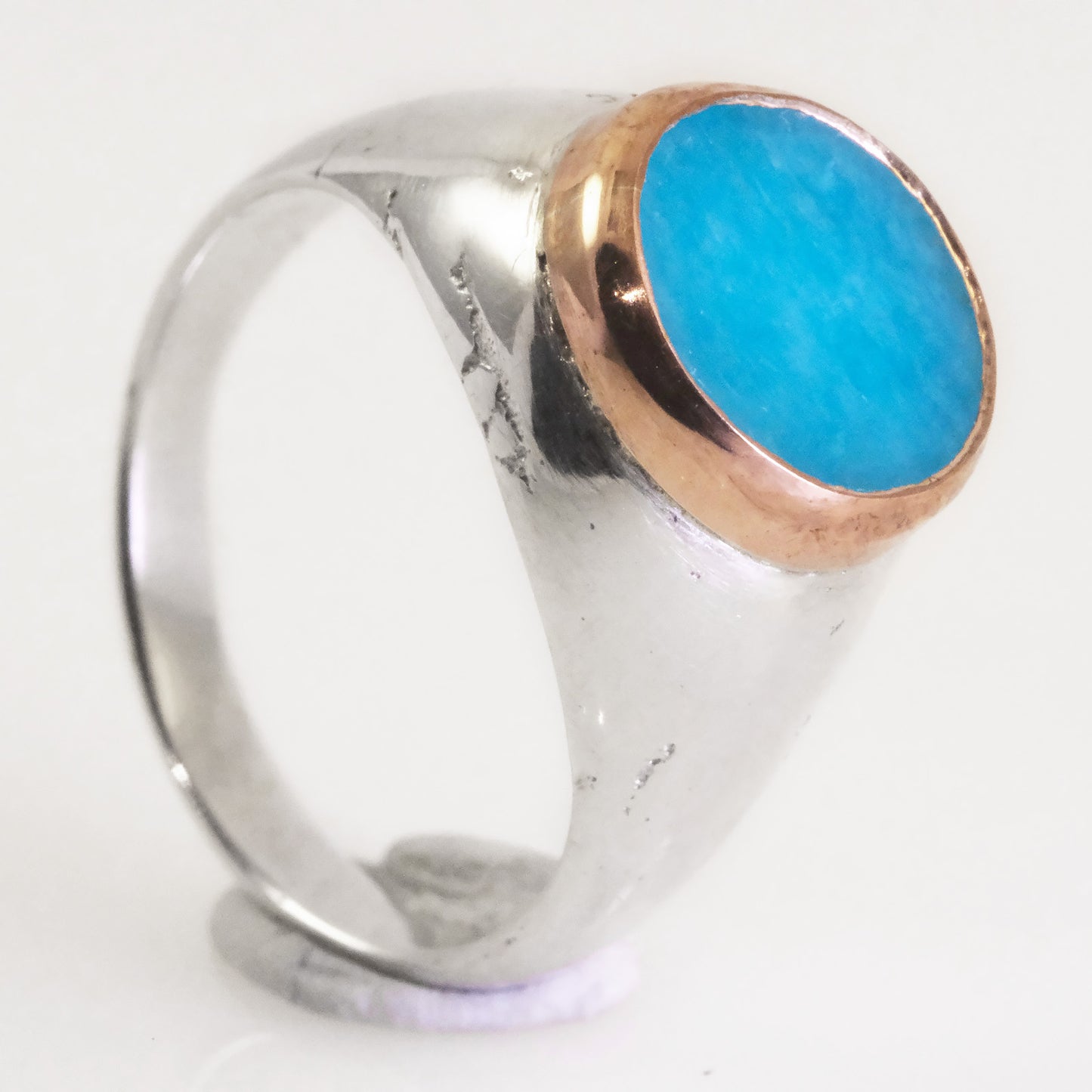 Close-up of blue amazonite stone in copper bezel on handcrafted silver signet ring